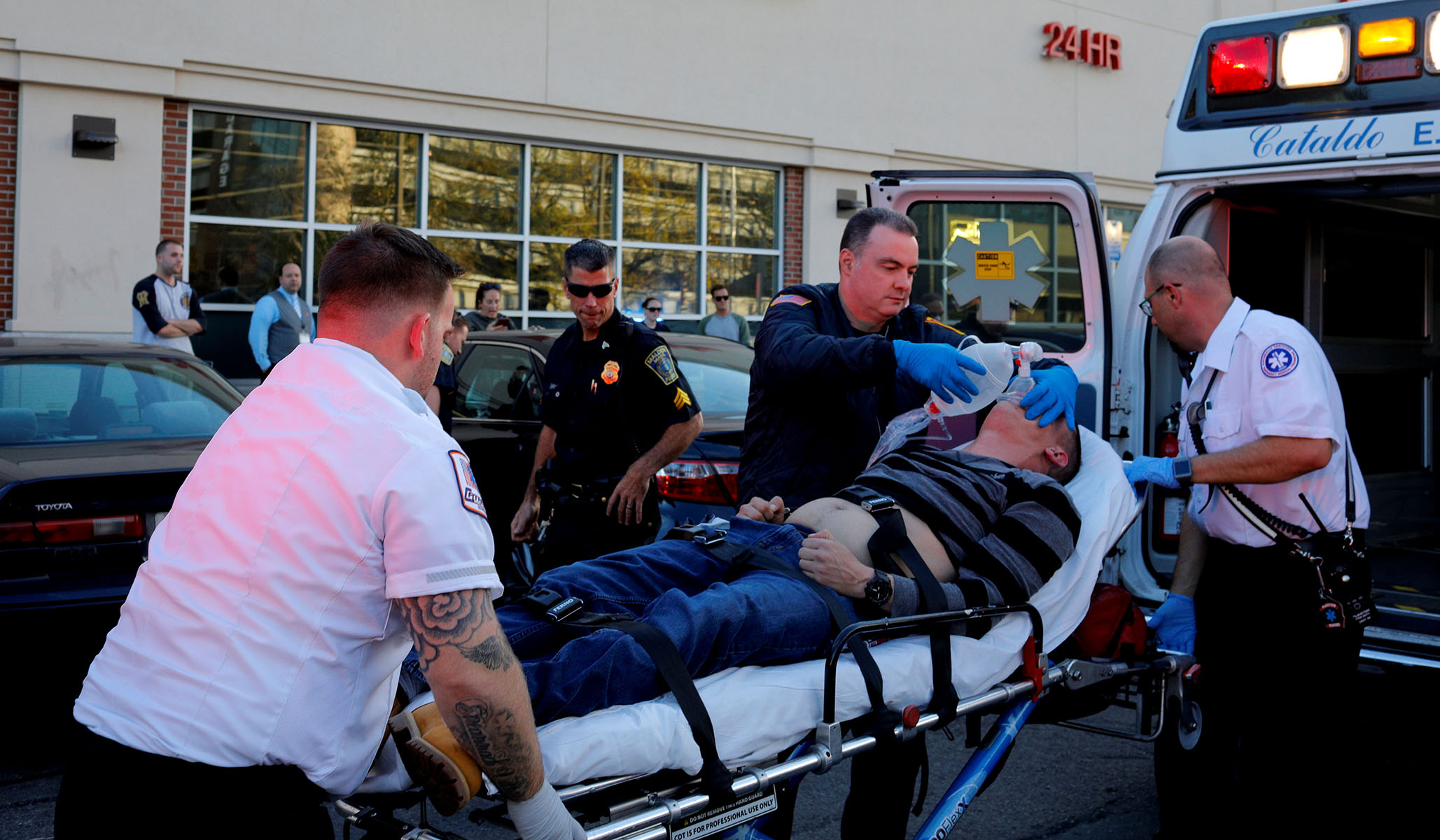 Cataldo Ambulance medics Timothy Stahl (left) and Derek Travers (right), with the help of a firefighter tend to a 38-year-old man who was found unresponsive after an opioid overdose in the Boston suburb of Malden, Mass., October 19, 2017. (Brian Snyder/Reuters)